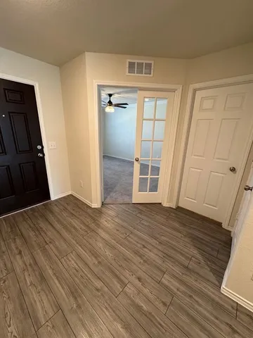 a view of empty room with wooden floor