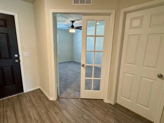 an empty room with wooden floor and cabinet