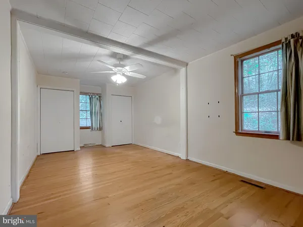 a view of an empty room with a chandelier fan