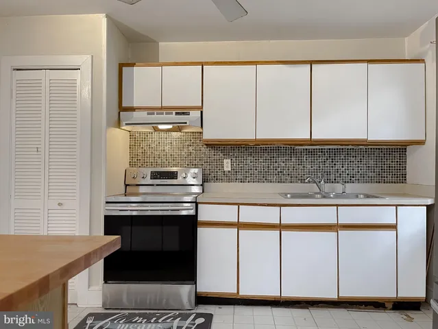 a kitchen with a refrigerator sink and cabinets