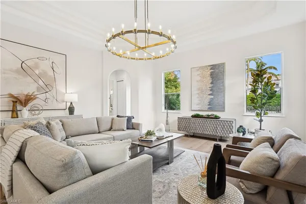 a living room with furniture chandelier and a large window