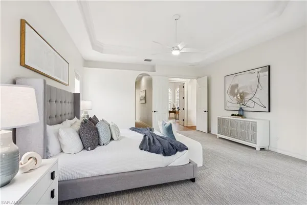 a spacious bedroom with a bed and a chandelier