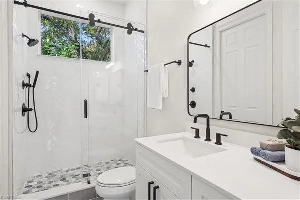 a bathroom with a sink a toilet and shower