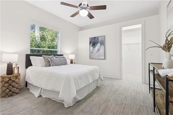 a large bed sitting in a bedroom next to a window with a chandelier
