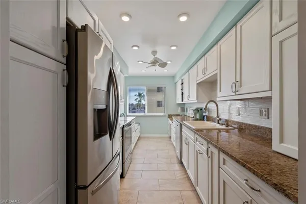 a large kitchen with stainless steel appliances granite countertop a lot of counter space and a sink