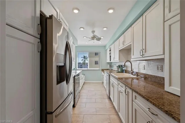 a large kitchen with stainless steel appliances granite countertop a lot of counter space and a sink