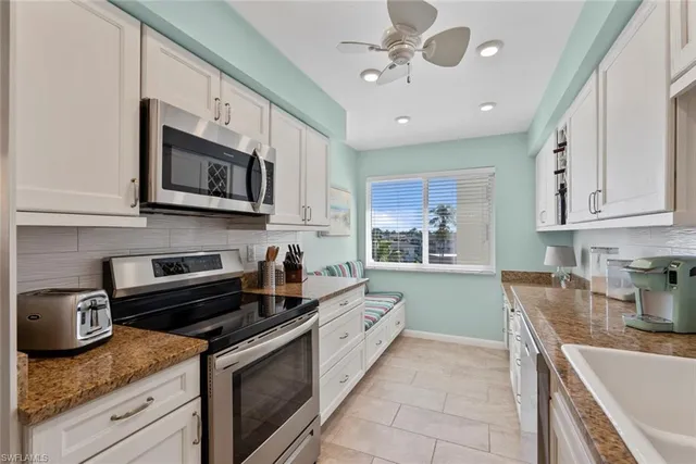 a kitchen with stainless steel appliances granite countertop a sink and a stove