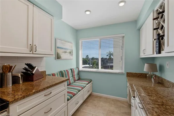 a kitchen with granite countertop a sink a stove and cabinets