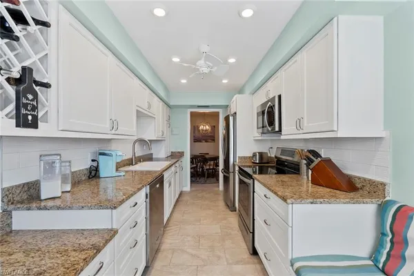 a kitchen with stainless steel appliances granite countertop a sink stove and cabinets