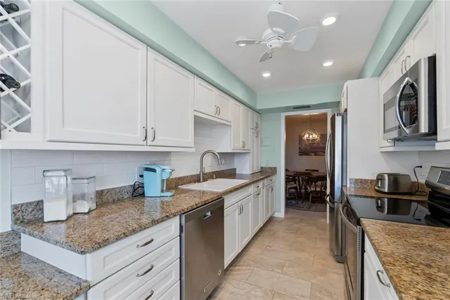 a kitchen with stainless steel appliances granite countertop a sink stove oven and refrigerator
