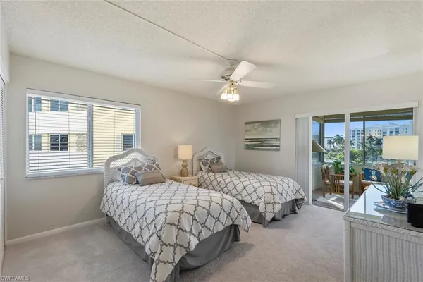 a bedroom with two beds and a large window