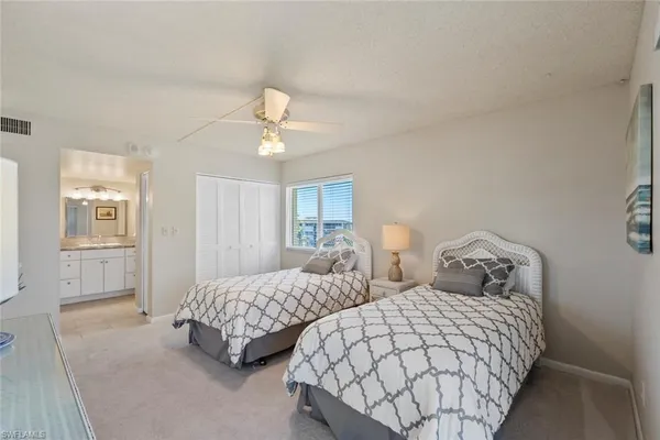 a bedroom with two beds and painting on the wall