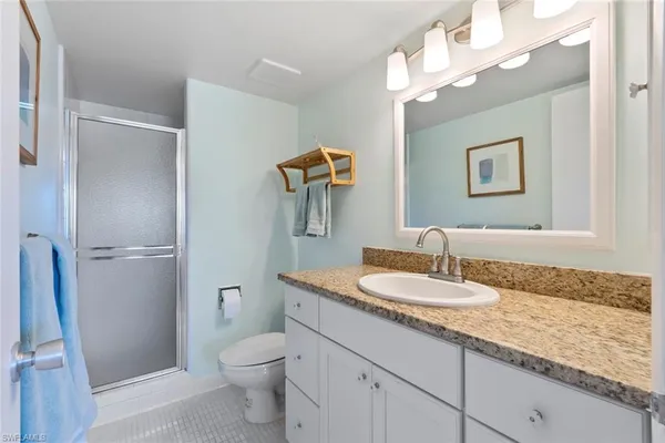a bathroom with a granite countertop sink a toilet and a mirror