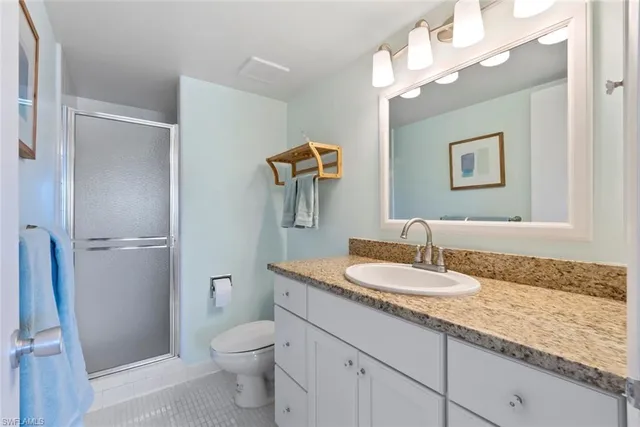 a bathroom with a granite countertop sink a toilet and a mirror