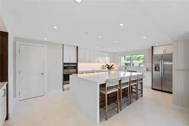 a kitchen with a dining table chairs and refrigerator