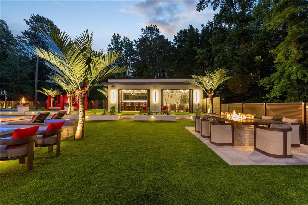 1386 Moores Mill Road Northwest Atlanta, GA 30327 - Photo 20 of 57 a view of a house with a backyard and a patio