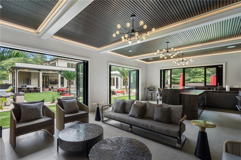 1386 Moores Mill Road Northwest Atlanta, GA 30327 - Photo 23 of 57 a living room with furniture a chandelier and a dining table