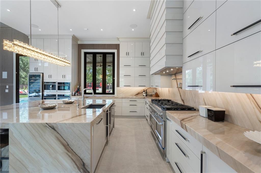 1386 Moores Mill Road Northwest Atlanta, GA 30327 - Photo 42 of 57 a large kitchen with stainless steel appliances granite countertop a lot of counter space and a sink
