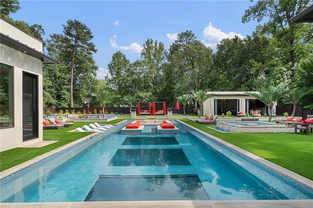 1386 Moores Mill Road Northwest Atlanta, GA 30327 - Photo 55 of 57 a front view of a house with swimming pool having outdoor seating