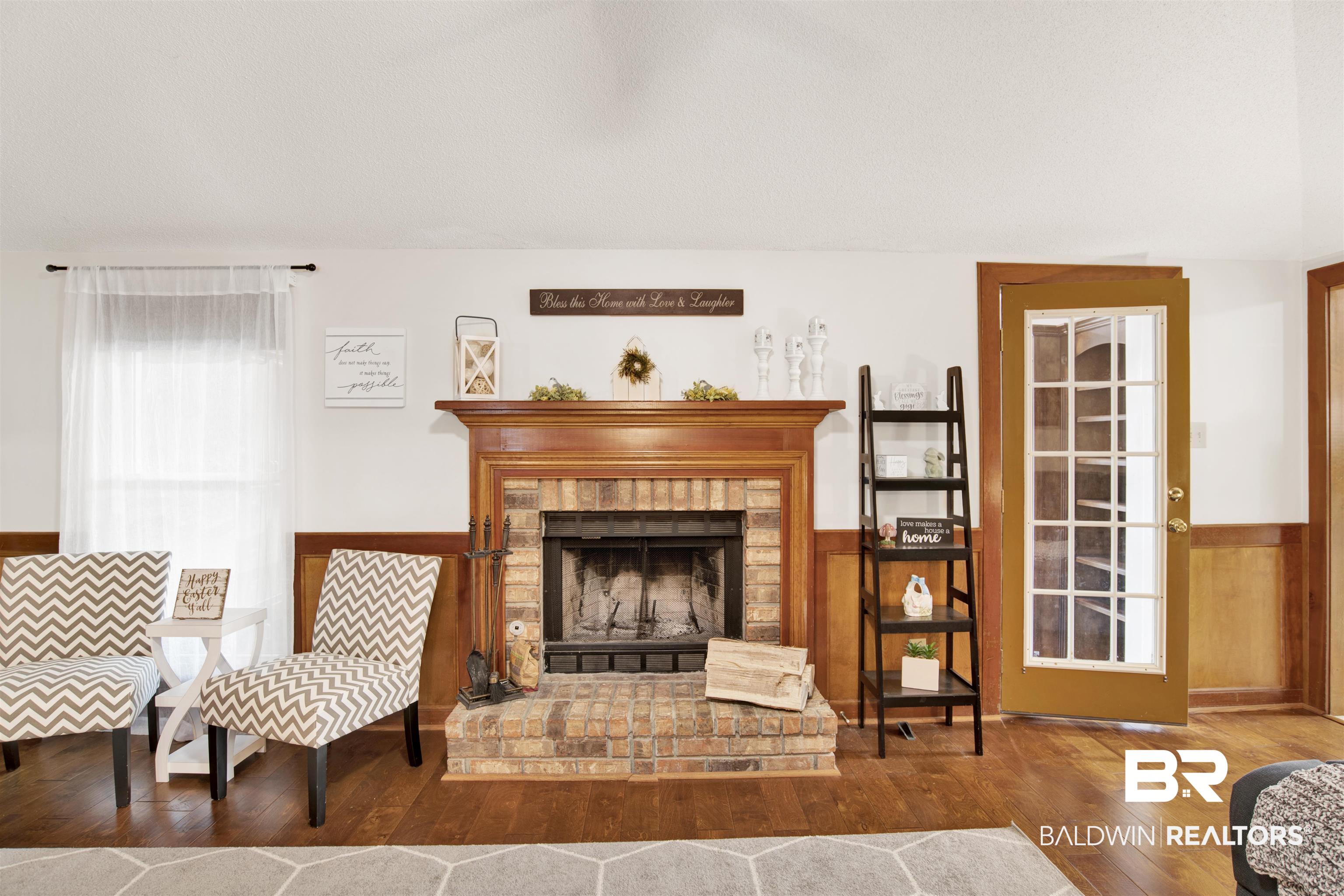 7431 Summer Court Mobile, AL 36695 - Photo 32 of 37 Living area with hardwood / wood-style flooring, wainscoting, and a fireplace