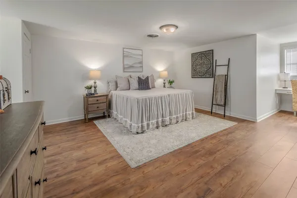 a bedroom with furniture and a wooden floor