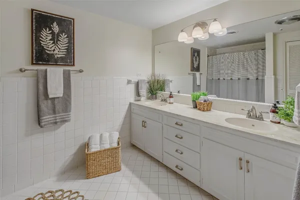 a bathroom with double vanity sink a mirror and a bathtub