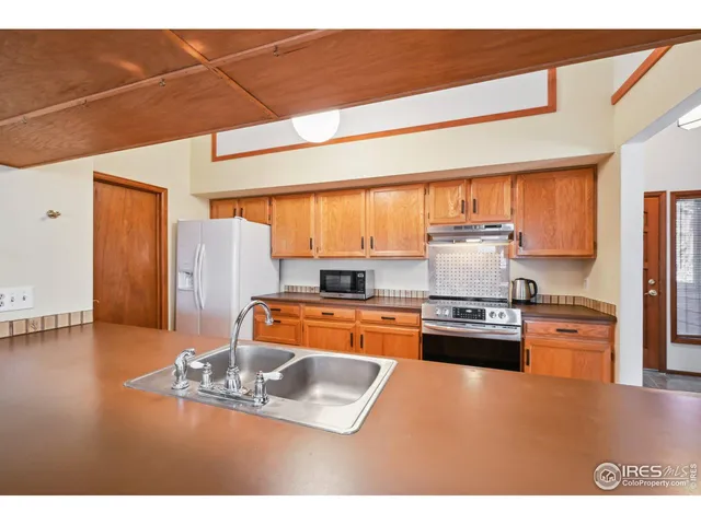 a large kitchen with stainless steel appliances granite countertop a lot of counter space and a sink