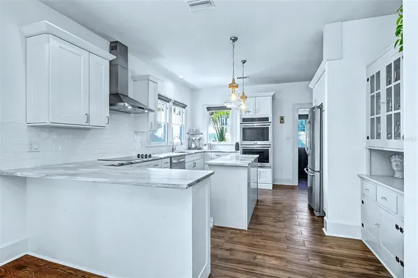 a kitchen with stainless steel appliances granite countertop a sink a stove and a refrigerator