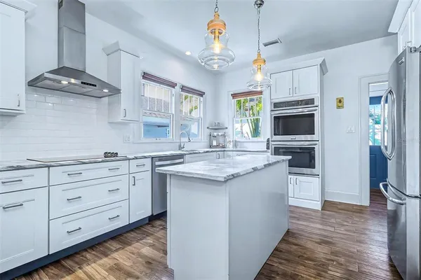 a kitchen with granite countertop a sink stove and cabinets