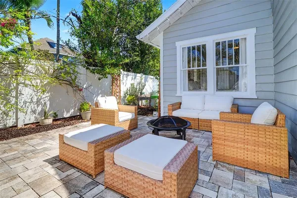a view of a patio with couches and table with wooden floor and fence