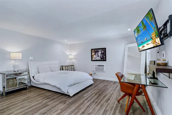 a bedroom with a bed and a wooden floor