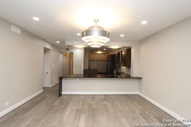 a view of kitchen with chandelier and wooden floor