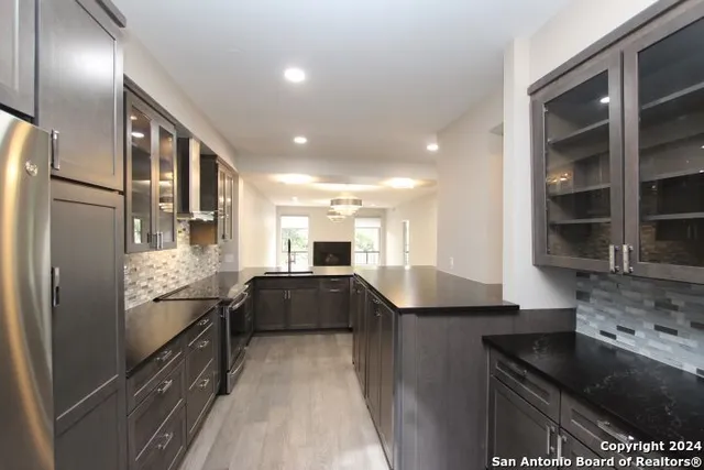 a kitchen with stainless steel appliances granite countertop a refrigerator and a sink