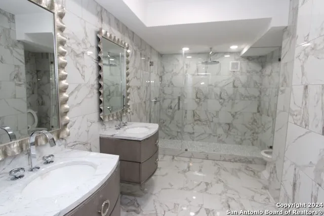 a bathroom with a sink shower and a mirror