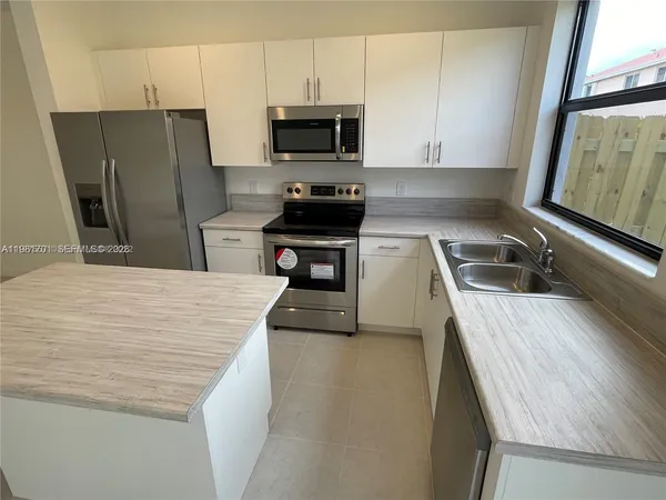 a kitchen with a refrigerator a stove and a sink