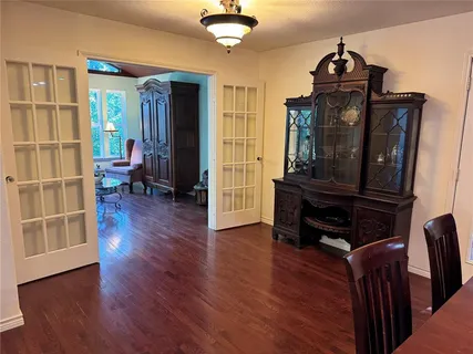 a living room with wooden floors and a piano