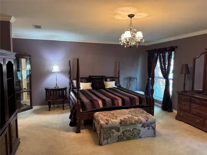 a bedroom with bed and a chandelier