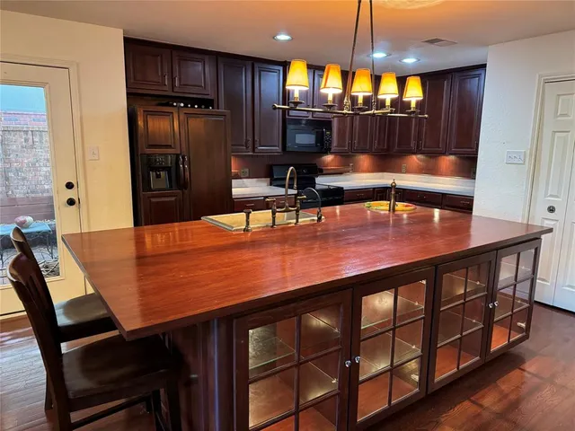 a kitchen with stainless steel appliances wooden floor dining table and chairs