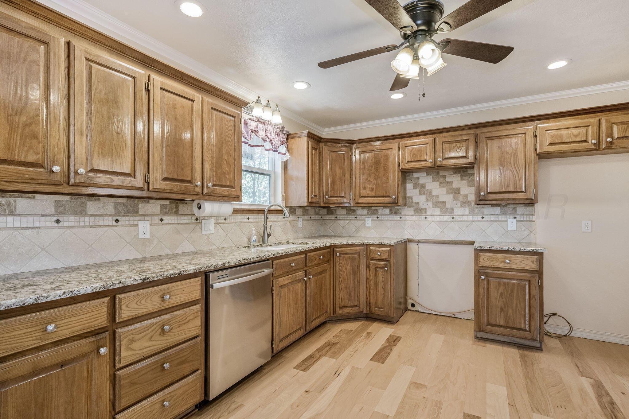 101 Mathis Drive Amarillo, TX 79118 - Photo 16 of 36 a kitchen with stainless steel appliances granite countertop a sink cabinets and wooden floor