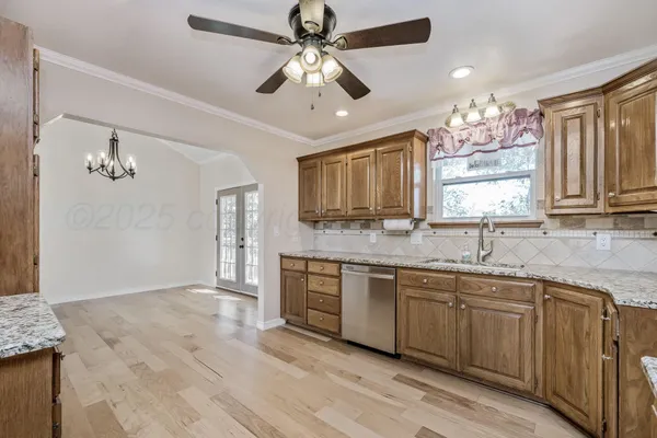 a large kitchen with granite countertop a stove sink and cabinets