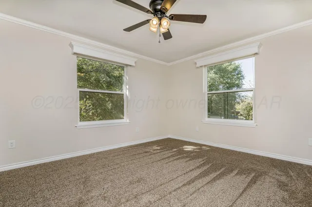 a view of a bedroom with a window and a ceiling fan