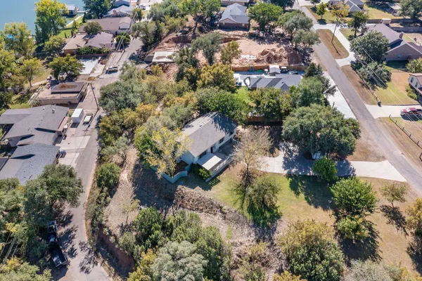 an aerial view of residential houses with outdoor space and trees all around