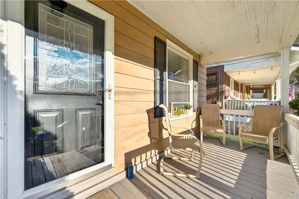 a balcony with chairs and glass door