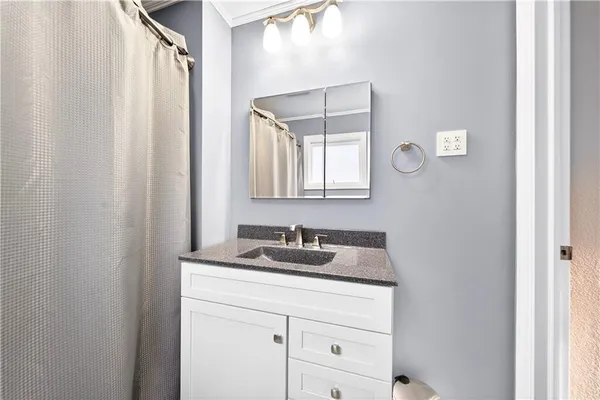 a bathroom with a granite countertop sink and a mirror