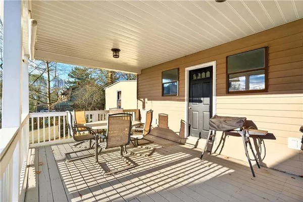 a view of a patio with table and chairs with wooden floor and fence