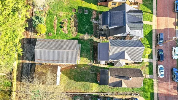 an aerial view of residential houses with outdoor space and street view