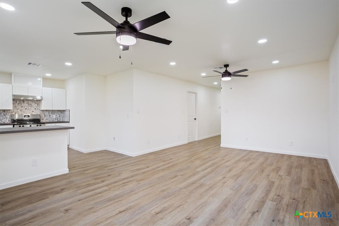 707 South 13th Street Temple, TX 76504 - Photo 7 of 24 a view of an empty room and kitchen with wooden floor