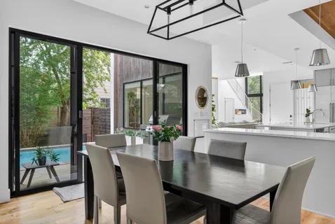 a living room with furniture a dining table and a potted plant