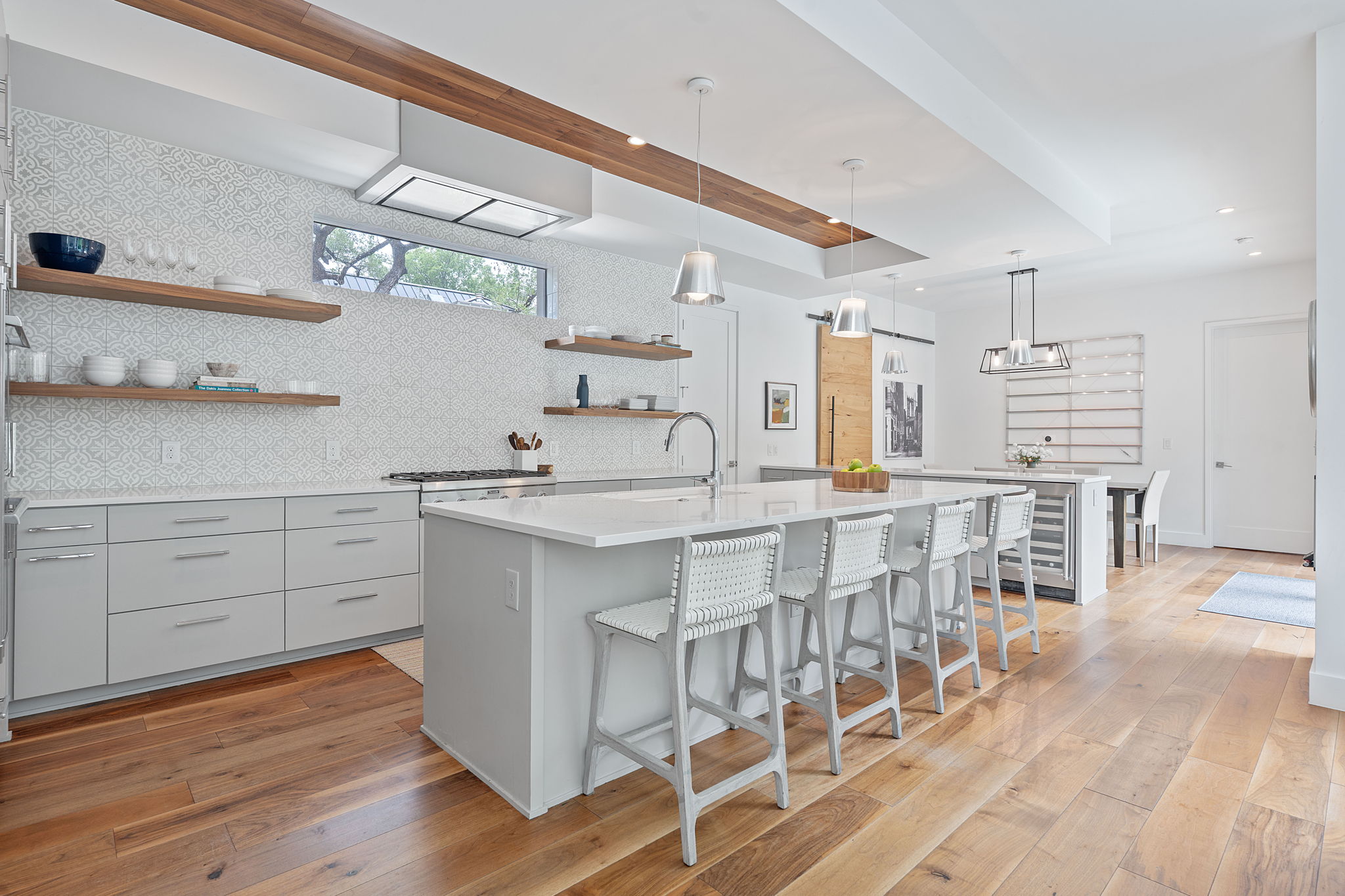 1605 Chelsea Lane, Unit 1 Austin, TX 78704 - Photo 3 of 38 Kitchen with gray cabinets, a center island with sink, open shelves, a breakfast bar area, and recessed lighting