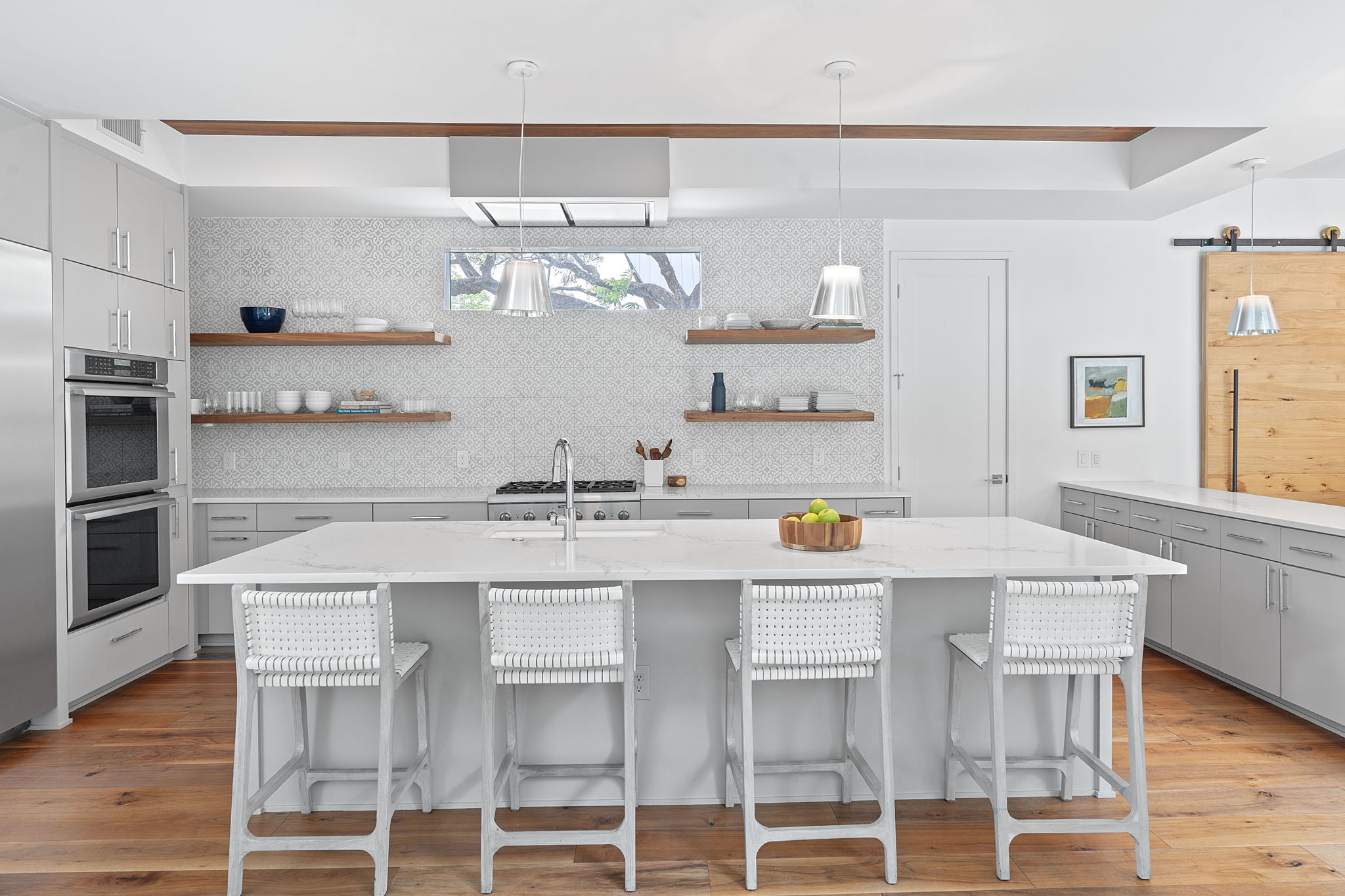 1605 Chelsea Lane, Unit 1 Austin, TX 78704 - Photo 9 of 38 Kitchen with gray cabinetry, stainless steel appliances, decorative backsplash, open shelves, and a kitchen island with sink